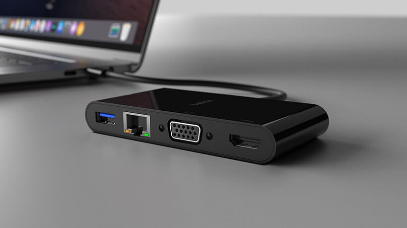 Adapter in foreground; laptop in background; gray/ grey.